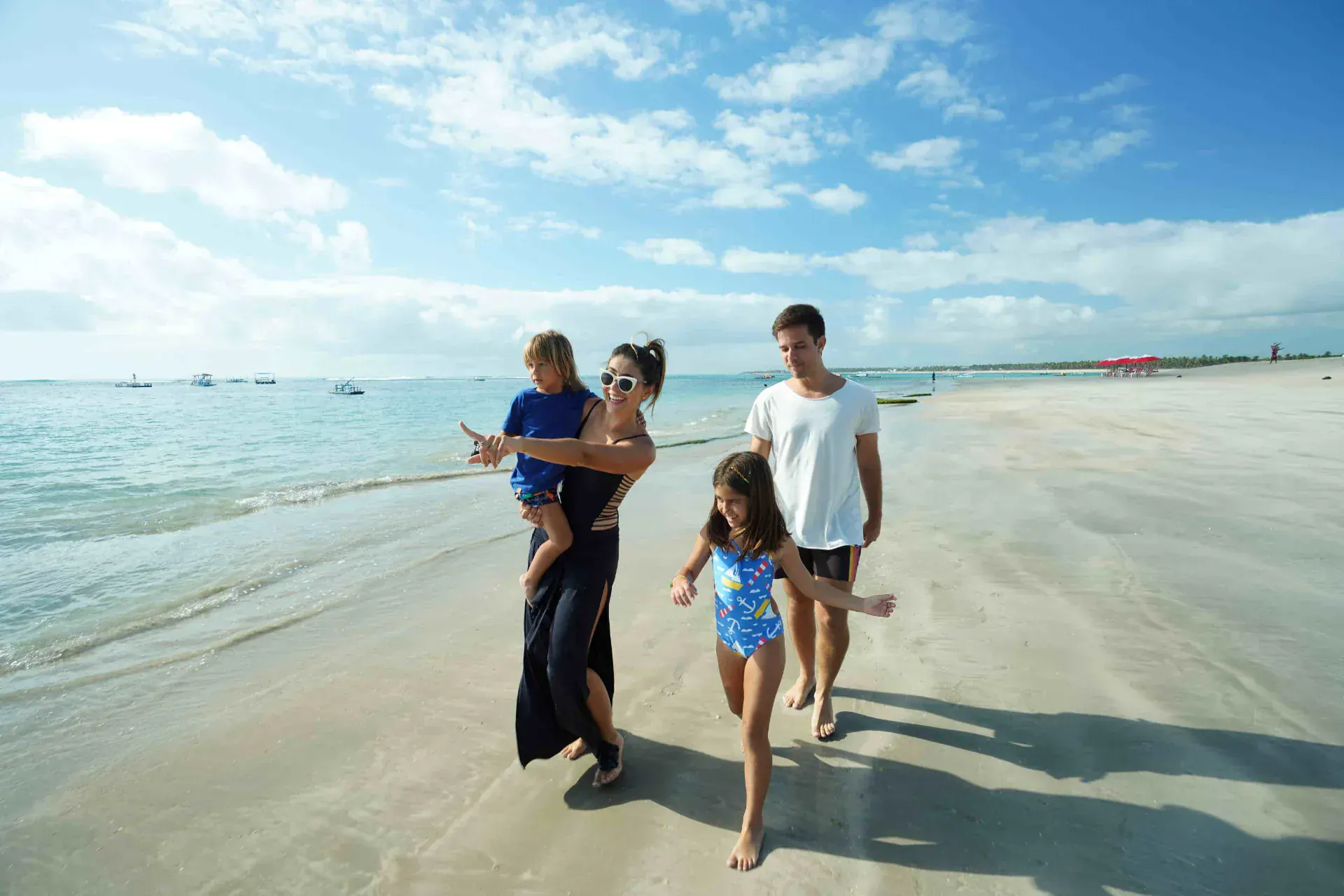 Família caminhando pela praia de Muro Alto em frente ao Samoa Beach Resort